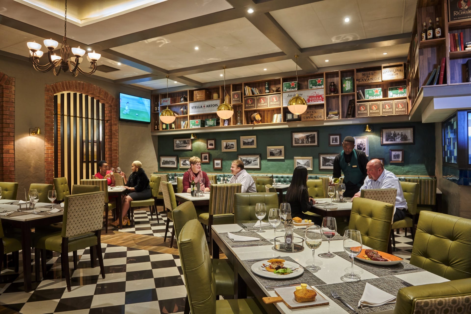 Diners at the Beef Baron Grillhouse with green booths at Frontier Inn, Bethlehem