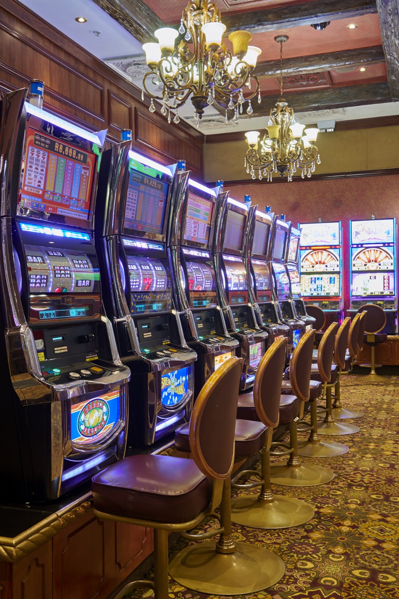 Slot machines beneath elegant chandeliers on the casino floor at Frontier Inn, Bethlehem