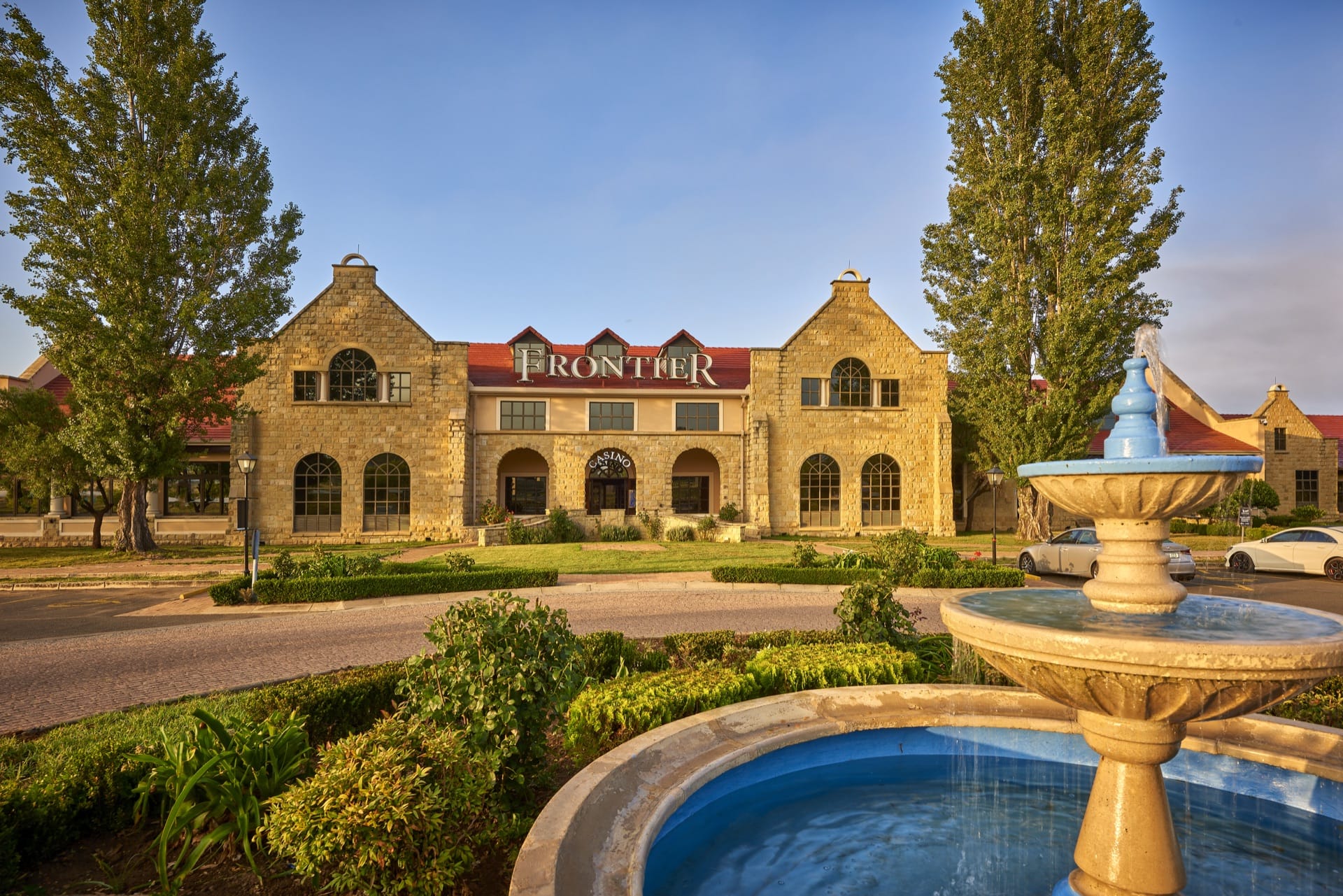 Stone facade and fountain at golden hour outside Frontier Inn, gateway to the Eastern Free State