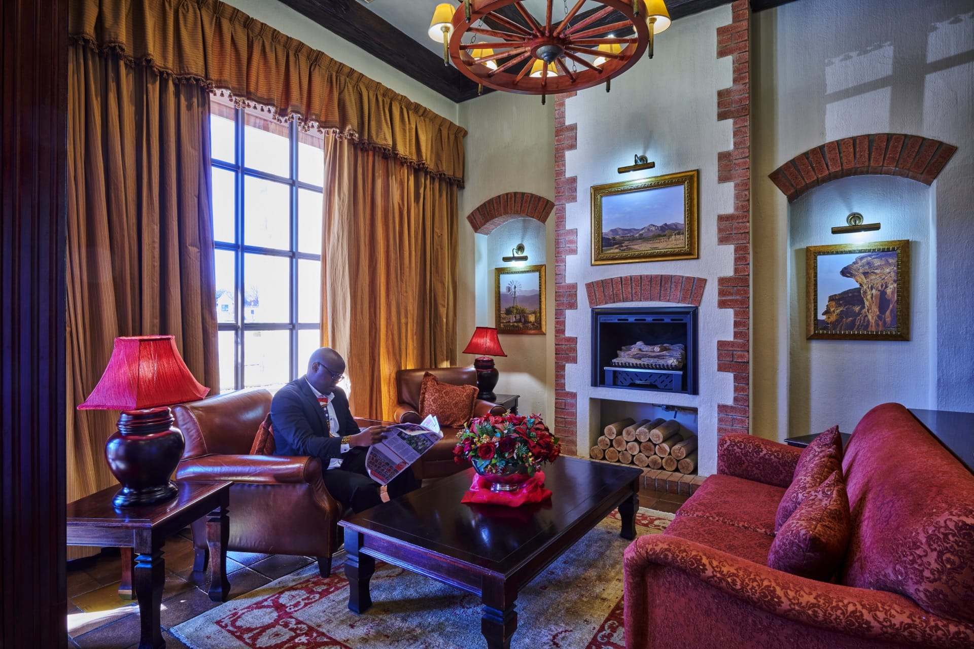 A guest relaxes by the fireplace in the reception lounge at Frontier Inn, Bethlehem