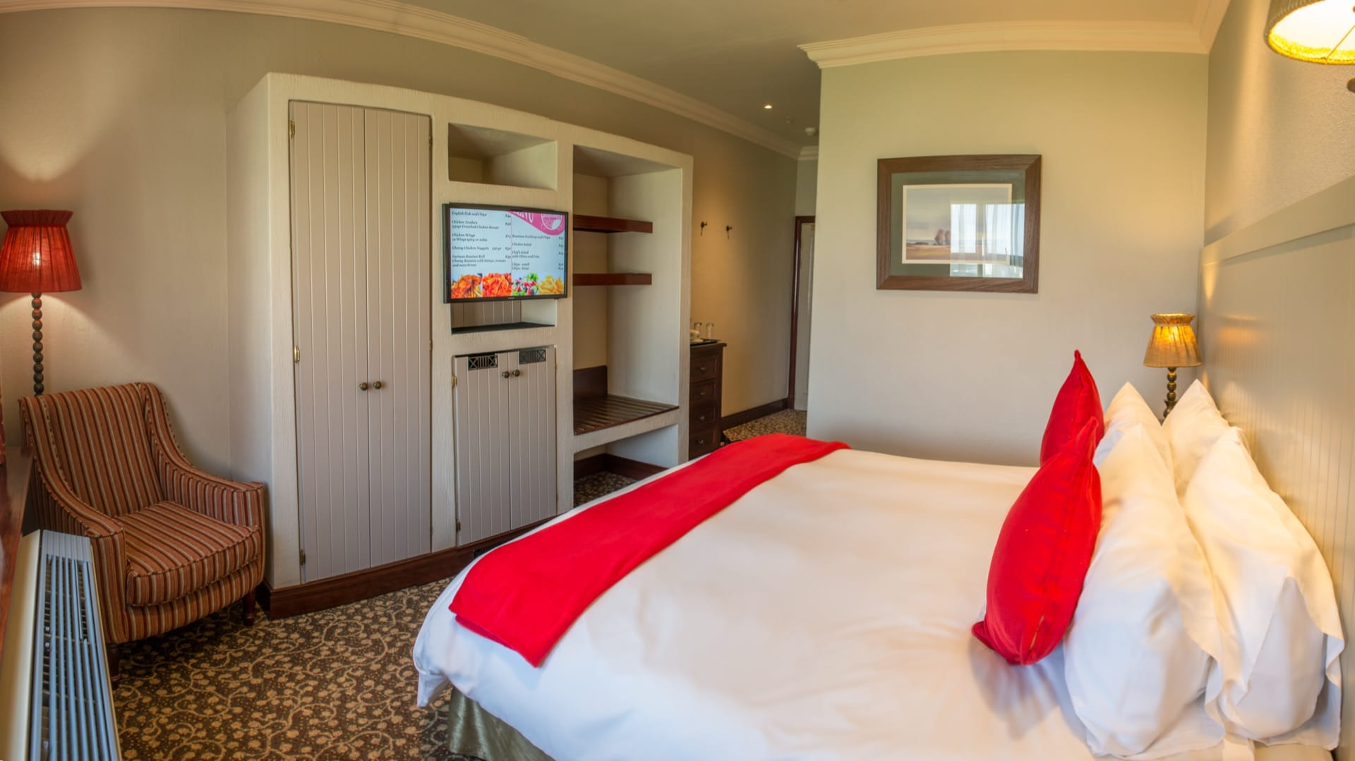 Spacious Junior Suite with double bed, wall-mounted television and built-in wardrobe at Frontier Inn, Bethlehem