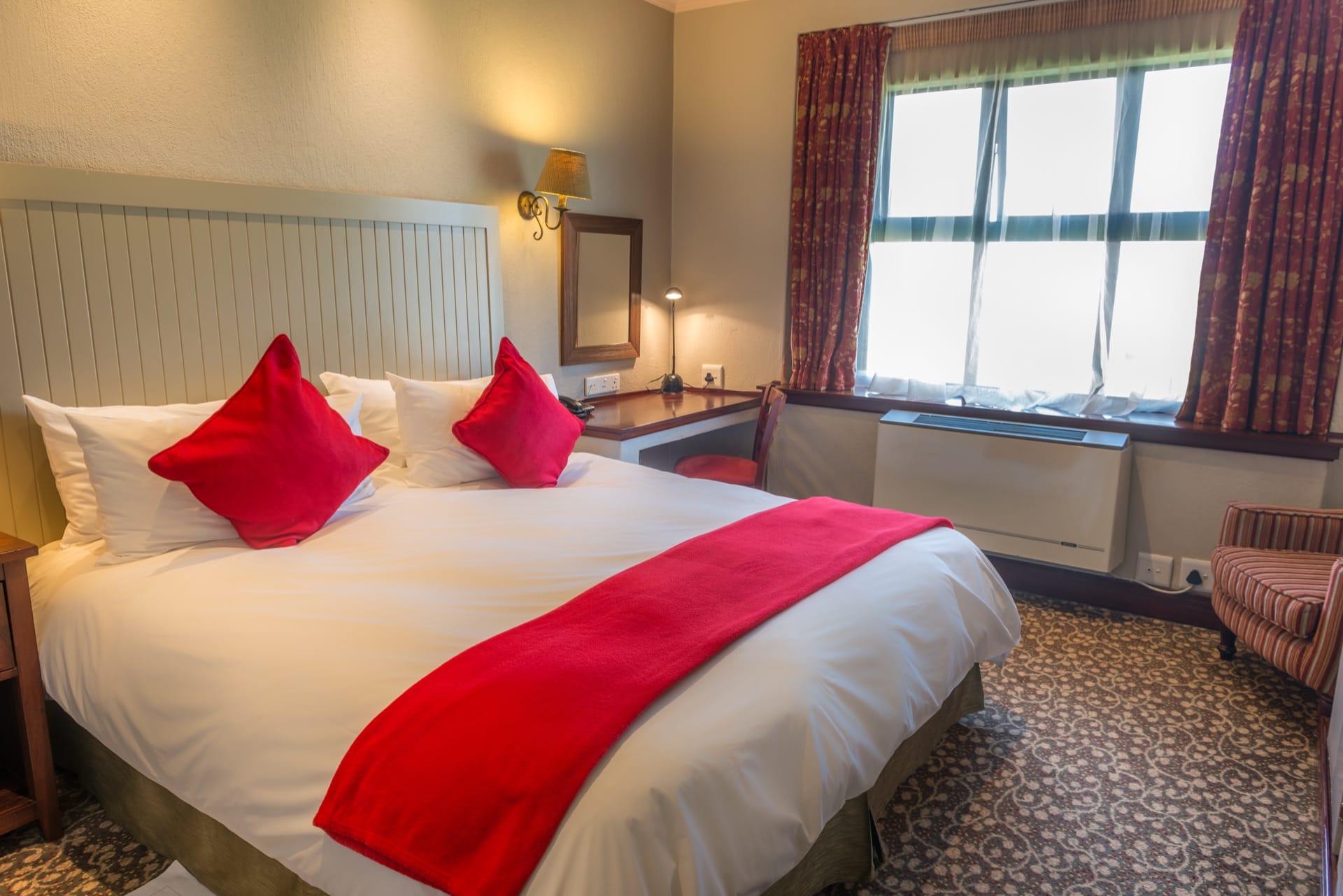 Junior Suite with double bed and desk beside a window at Frontier Inn, a 3-star hotel in Bethlehem